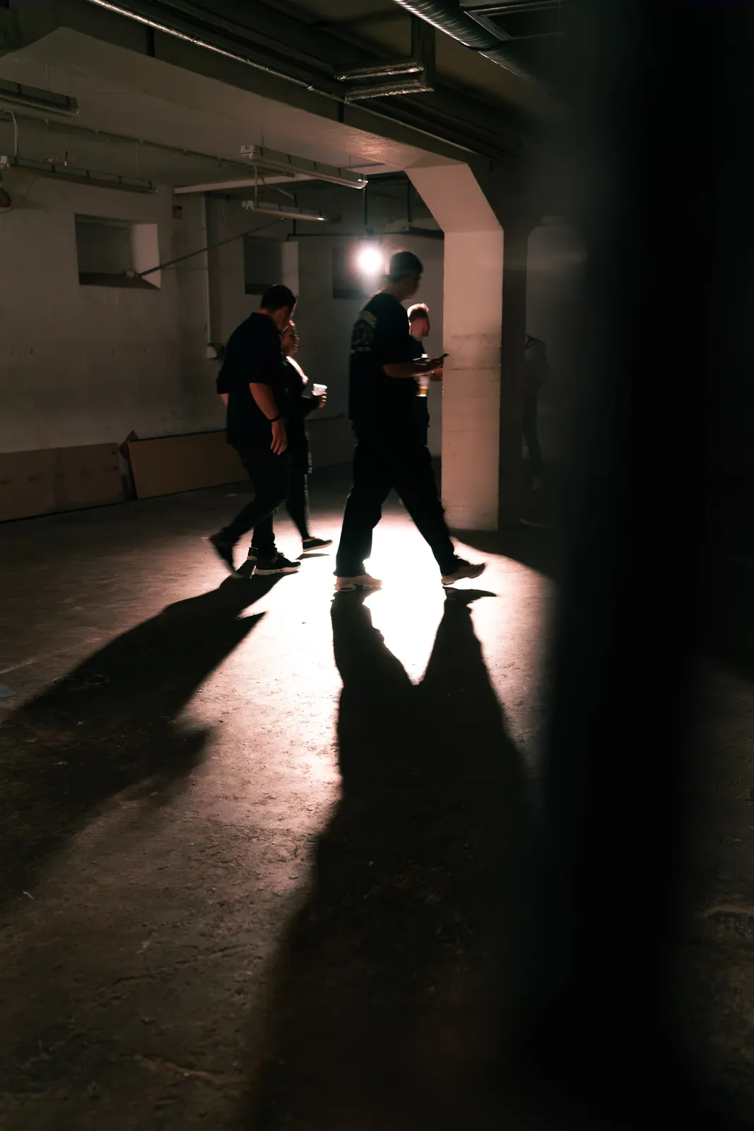 Zwei Silhouetten im Gegenlicht eines Fabrikgangs